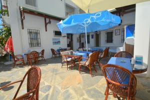 an outdoor patio with tables and chairs with blue umbrellas at Istankoy Butik Pansiyon in Bodrum City