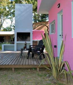 una casa rosa con una mesa y sillas en una terraza en Cabaña Descansos del Este en Costa del Este