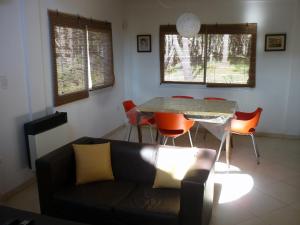 Una sala de estar con un sofá, una mesa y sillas. en Cabaña Descansos del Este, en Costa del Este