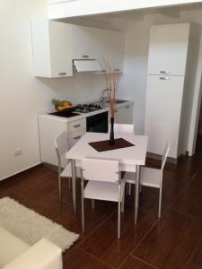 サン・ティジドーロにあるWhite Apartment Salentoの白いキッチン(白いテーブルと椅子付)