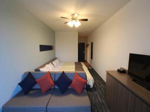 蒲郡市にある変なホテル ラグーナテンボスのベッド1台、薄型テレビが備わるホテルルームです。