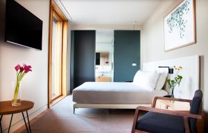a hotel room with a bed and a vase of flowers at Hotel Arima & Spa - Small Luxury Hotels in Donostia-San Sebastián
