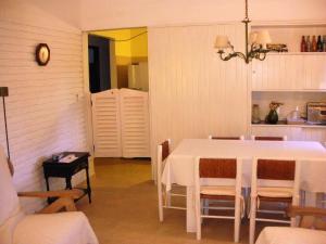 a dining room with a white table and chairs at Casas De Pinamar in Pinamar
