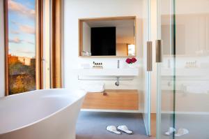 a bathroom with a tub and a sink and a mirror at Hotel Arima & Spa - Small Luxury Hotels in Donostia-San Sebastián