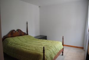 1 dormitorio con 1 cama con edredón verde en La caleta en Mar de Cobo