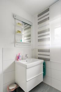 een witte badkamer met een wastafel en een spiegel bij Ferienwohnung Thiergarten in Mistelgau