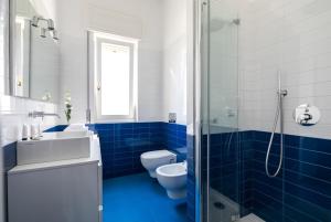 a blue and white bathroom with a toilet and a sink at Sant'Ambrogio Elegance in Milan