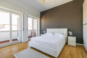 a bedroom with a white bed and two windows at Sant'Ambrogio Elegance in Milan