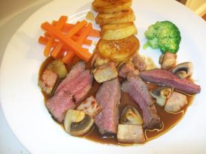un plato de comida con carne, verduras y zanahorias en Chapel House, en Atherstone