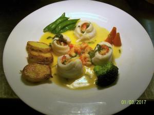 un plato blanco de comida con marisco y verduras en Chapel House en Atherstone