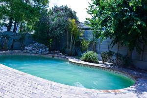 a small swimming pool in a yard with a fence at 34onlincoln Guesthouse in Bellville