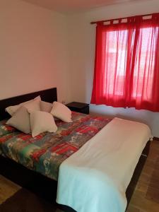 Parque HolandesにあるEl Arco Irisの赤い窓付きのベッドが備わるベッドルーム1室が備わります。