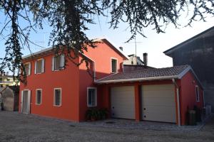 une maison rouge avec deux portes de garage dans l'établissement Residenza Il Salice, à Bagnolo San Vito