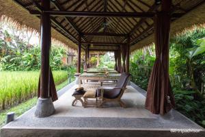 a gazebo with a table and chairs at Saren Indah Hotel in Ubud