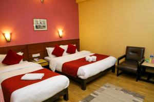 Llit o llits en una habitació de Hotel Silver Oaks Inn