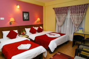 Llit o llits en una habitació de Hotel Silver Oaks Inn
