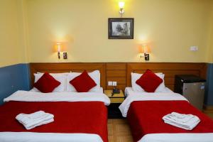Llit o llits en una habitació de Hotel Silver Oaks Inn