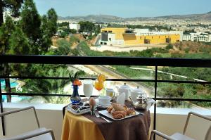 una mesa con un plato de comida en la parte superior de un balcón en Menzeh Zalagh 2Boutique Hôtel & Sky, en Fez