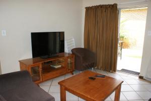a living room with a flat screen tv and a coffee table at Eric's Apartments in Centurion
