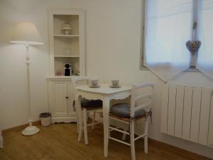 mały biały stół i krzesła w pokoju w obiekcie La Cordonnerie de Réau w mieście Réau