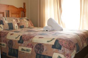 a bed with a stuffed animal sitting on top of it at Eric's Apartments in Centurion