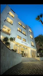 a large white building with a sign on it at Shams Alweibdeh Hotel Apartments in Amman