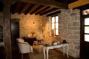 a living room with a table and a stone wall at El Coto Hotel Restaurante in Vitoria-Gasteiz