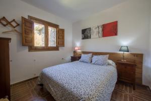 a bedroom with a bed and two windows at Apartamentos Balcon del Cielo in Trevélez