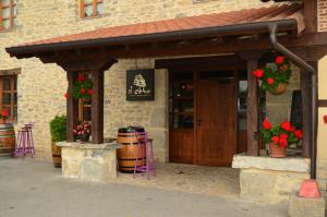 - un bâtiment avec une porte et des fleurs dans l'établissement El Coto Hotel Restaurante, à Vitoria-Gasteiz