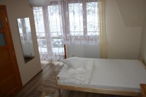 a bedroom with a bed and a large window at Zawojska Przystań in Zawoja