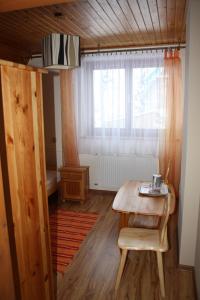 a room with a wooden table and a window at Zawojska Przystań in Zawoja