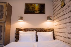 - une chambre avec un lit doté d'oreillers blancs et de deux lumières dans l'établissement All In Apartman II., à Budapest