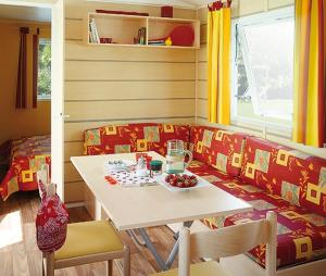 Camping de l'Arche في Lanas: غرفة معيشة مع طاولة وأريكة