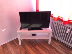 レーゲンスブルクにあるAppartement Redhouseの部屋の白いテーブルにテレビが付いています。