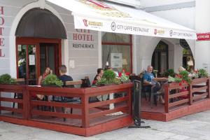 eine Gruppe von Personen, die vor einem Restaurant sitzen in der Unterkunft Hotel City Pisek in Písek