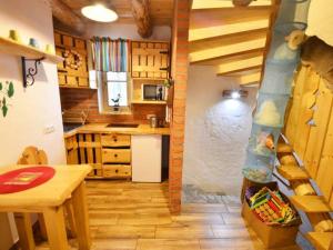 una cocina con una escalera que conduce a una cocina con mesa en Uroczysko en Brenna