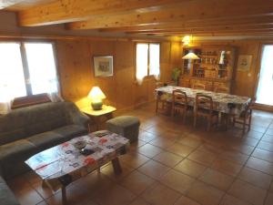 ein Wohnzimmer mit einem Sofa und einem Tisch in der Unterkunft Chalet Xenia in Crans-Montana