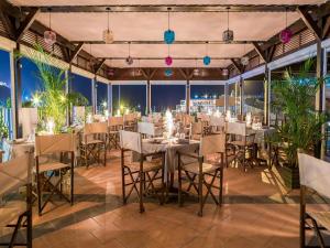 uma sala de jantar com mesas, cadeiras e luzes em Idyll Suites - Adults Only em Playa del Cura
