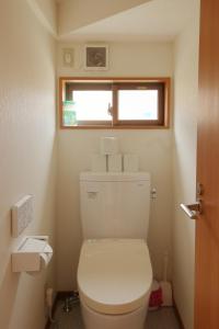 niewielka łazienka z toaletą i oknem w obiekcie Cottage Pastorale w mieście Fujikawaguchiko