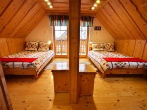 a bedroom with two beds in a wooden cabin at Uroczysko in Brenna