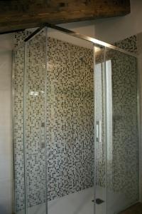 y baño con ducha de cristal y paredes de azulejos. en La Panera del Carbain, en Soto del Barco