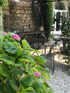 a patio with a table and benches and flowers at Domaine de la Manse in Villeneuve-de-Berg