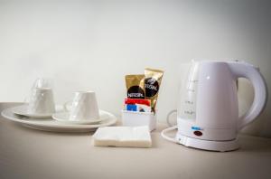 a coffee maker sitting next to plates and cups at Magione del Re in Catania
