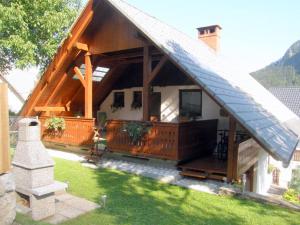 a house with a large porch with a roof at Apartmaji Taler in Bohinj