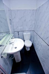 a white bathroom with a toilet and a sink at HOSTEL KATUNAYAKE At COLOMBO AIRPORT TRANSIT in Katunayake