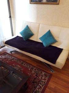 a white couch with two blue pillows on it at Apartment 209 in Santiago