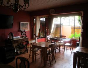 a dining room with tables and chairs and a television at Hotel Boutique Las Azucenas in Constitución