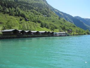a row of huts on the side of a lake at Nesheim Hytter & Camping in Bjordal