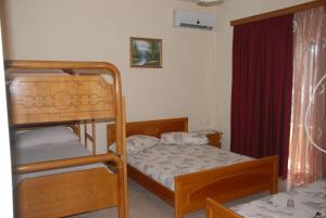 a bedroom with two bunk beds and a red curtain at Olive Tree in Sarandë