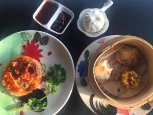 a table with plates of food and a bowl of dip at Baan Bangrak Residence in Trang
